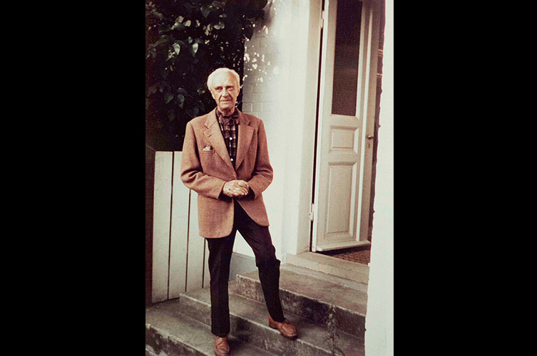 Nutida foto av Ernst Fischer i kostym på en trappa.