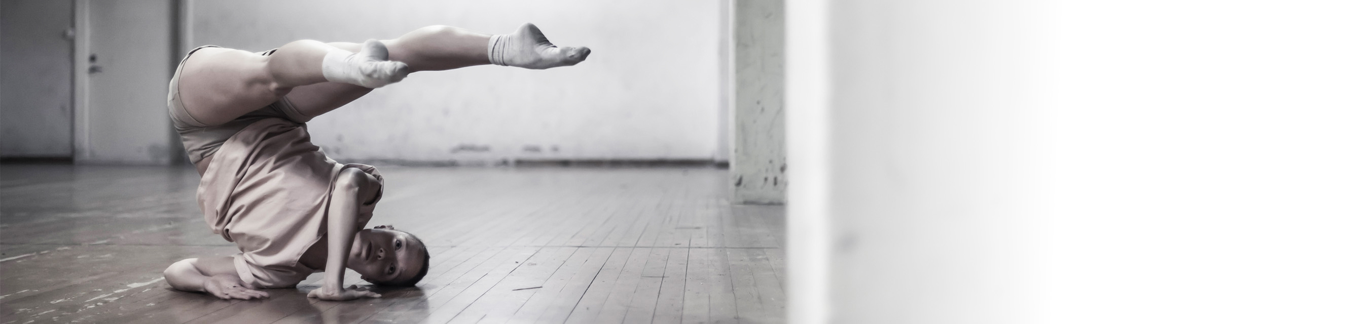Danselev utför en akrobatisk dansposition i en studio.