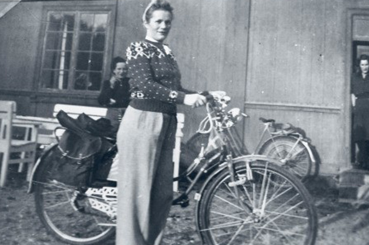 Äldre svart-vitt foto på kvinna med cykel. 