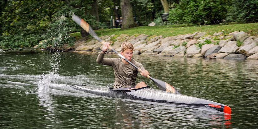 En kille som paddlar kanot i Kungsparken i Malmö