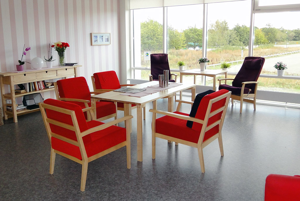 Allrummet har stora fönster och de röda fåtöljerna ger färgstark energi till rummet.