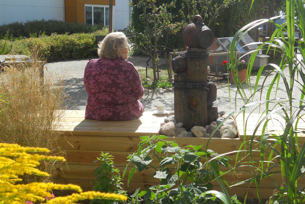 I trädgården kan man slå sig ner på en bänk och njuta av en kopp kaffe.