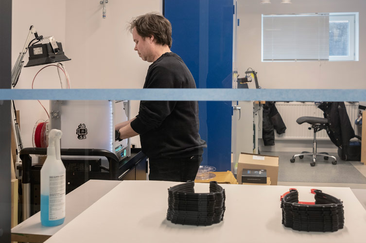 Museitekniker Mats lossar ett färdigt skyddsvisir från 3D-skrivaren, som ska levereras till sjukvården.