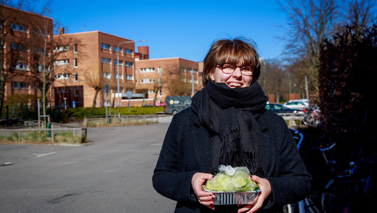 Kvinna med matlåda i handen.