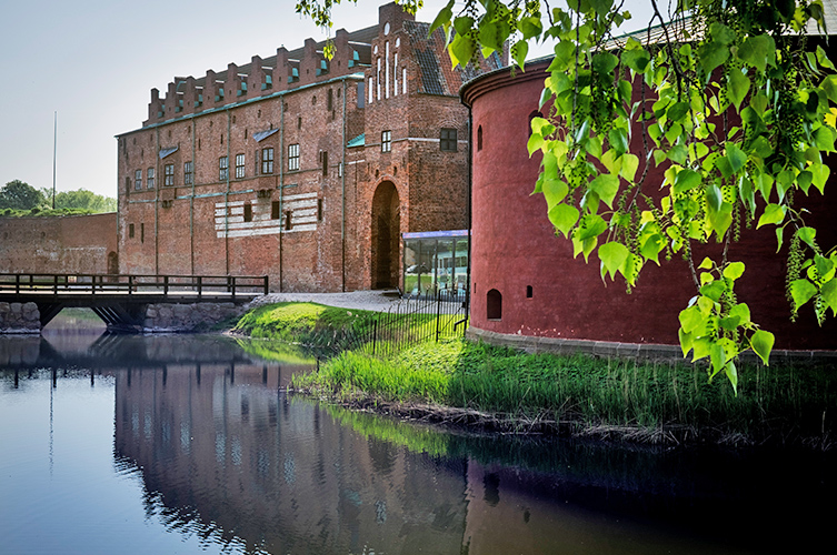Grönskande miljö kring slottet och vallgraven.