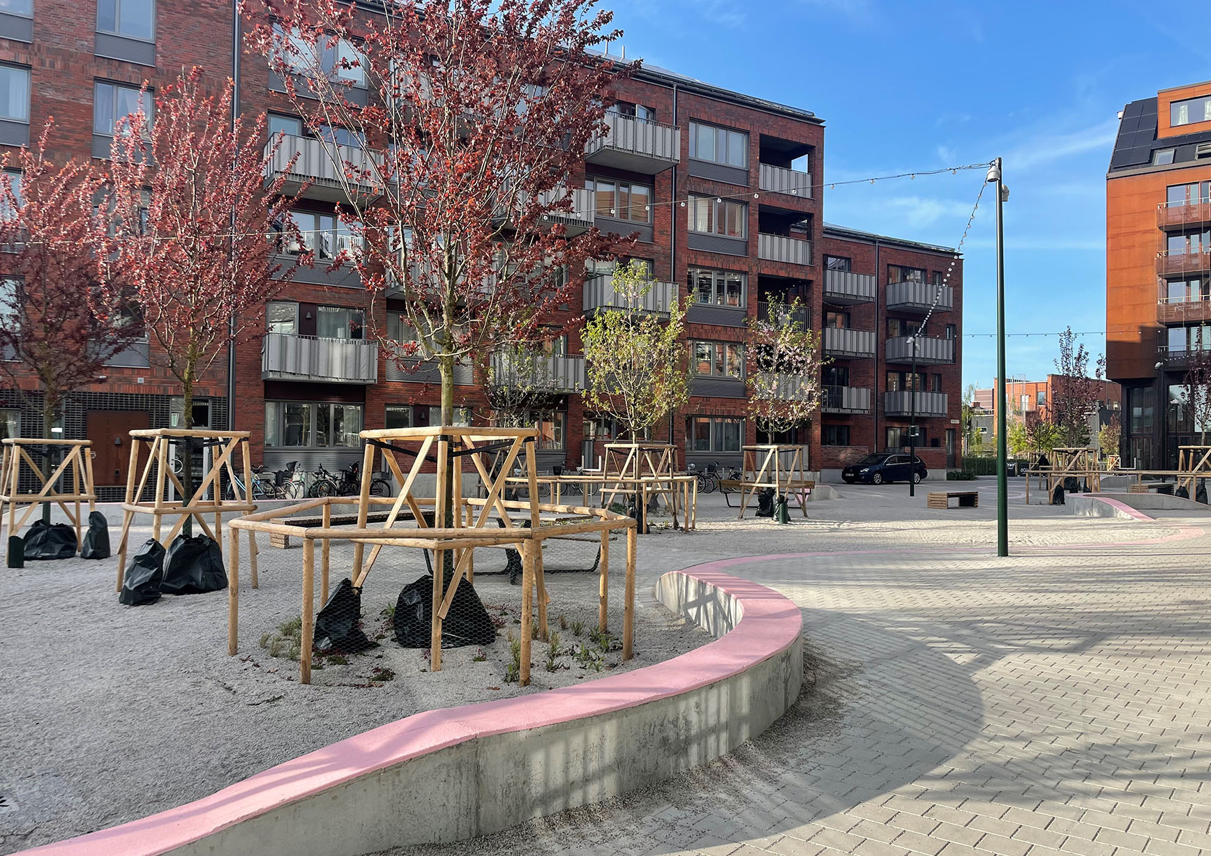 Torg med rosa slingrande bänkar och nya träd står på Spiggans plats.