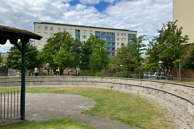 Liten stenlagd amfiteater i ett bostadsområde, i bakgrunden syns flera högre flerfamiljshus.