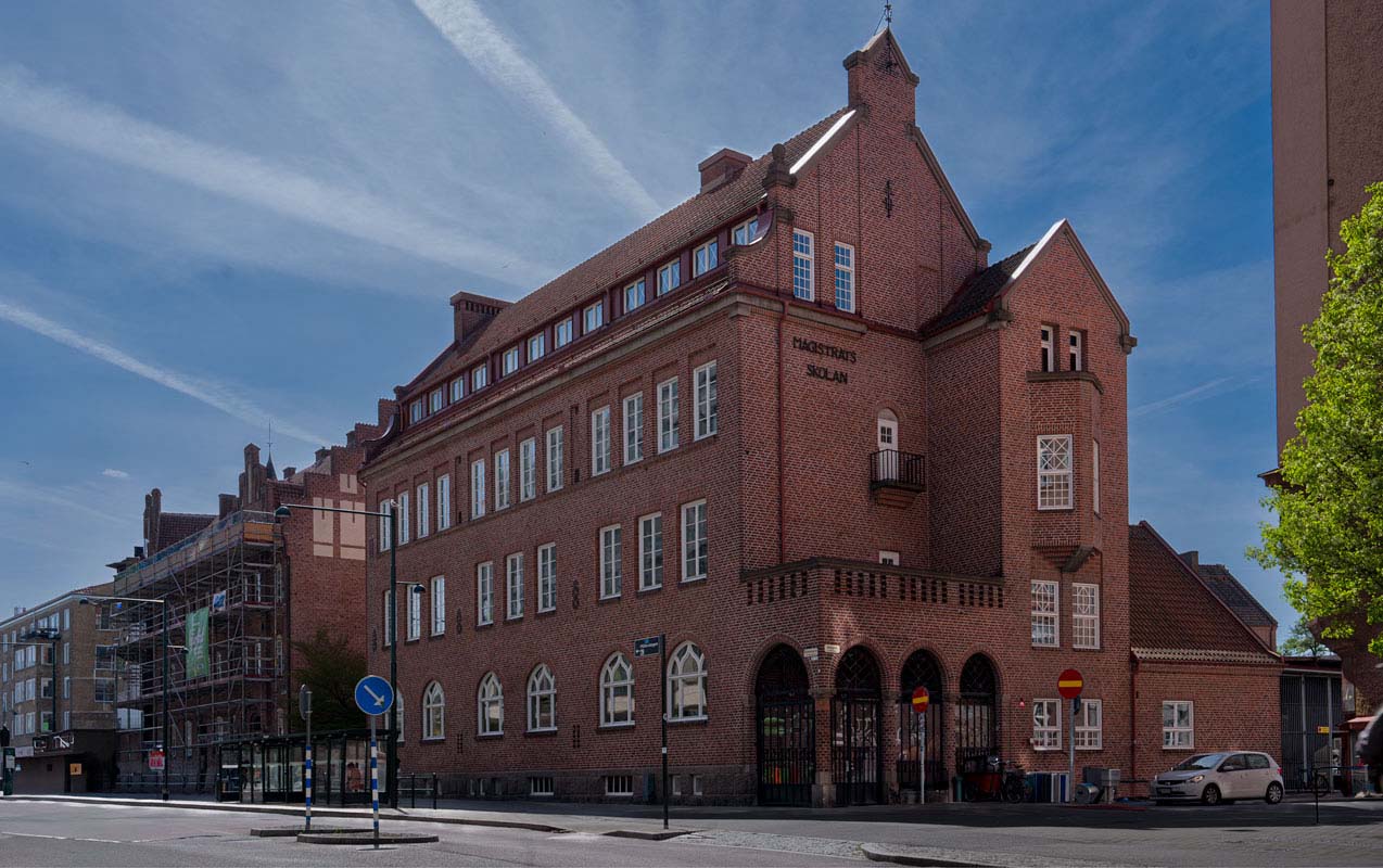 En äldre röd tegelbyggnad med många vita fönster.