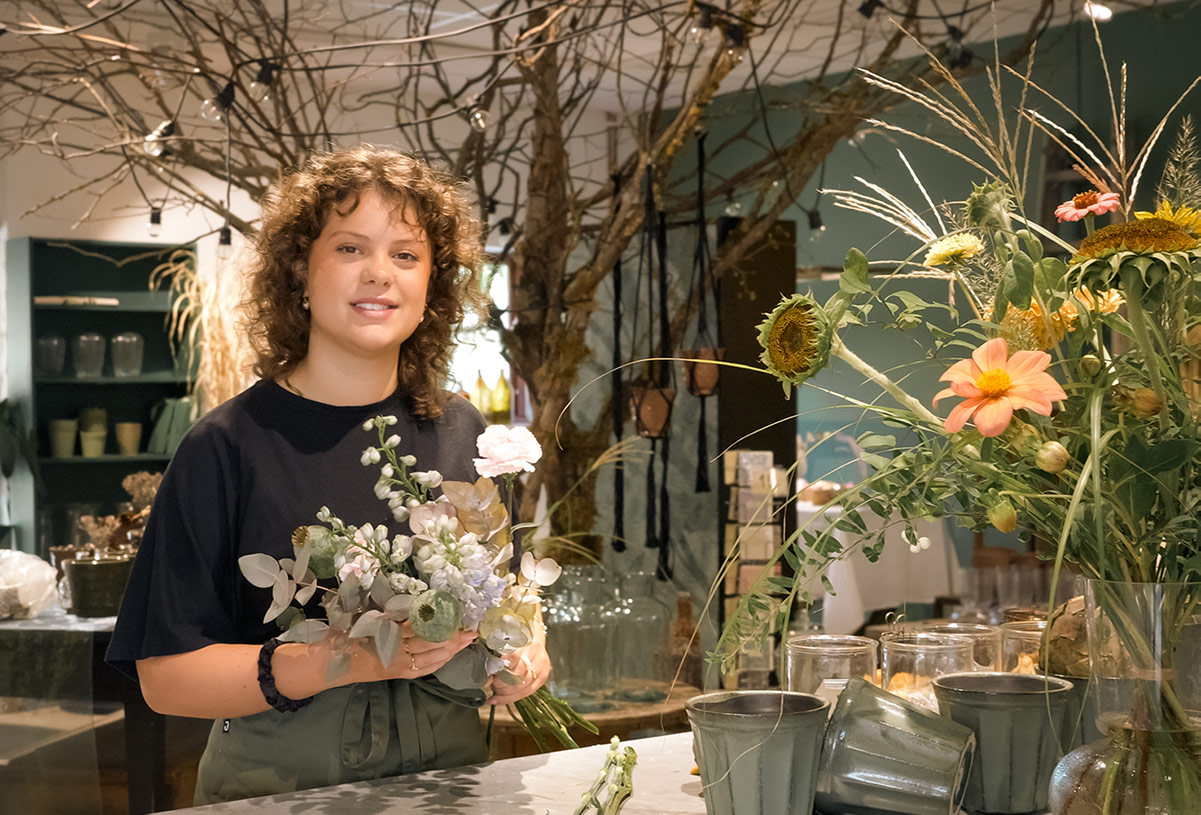 Elev på utbildningen till florist sätter ihop en vacker bukett.