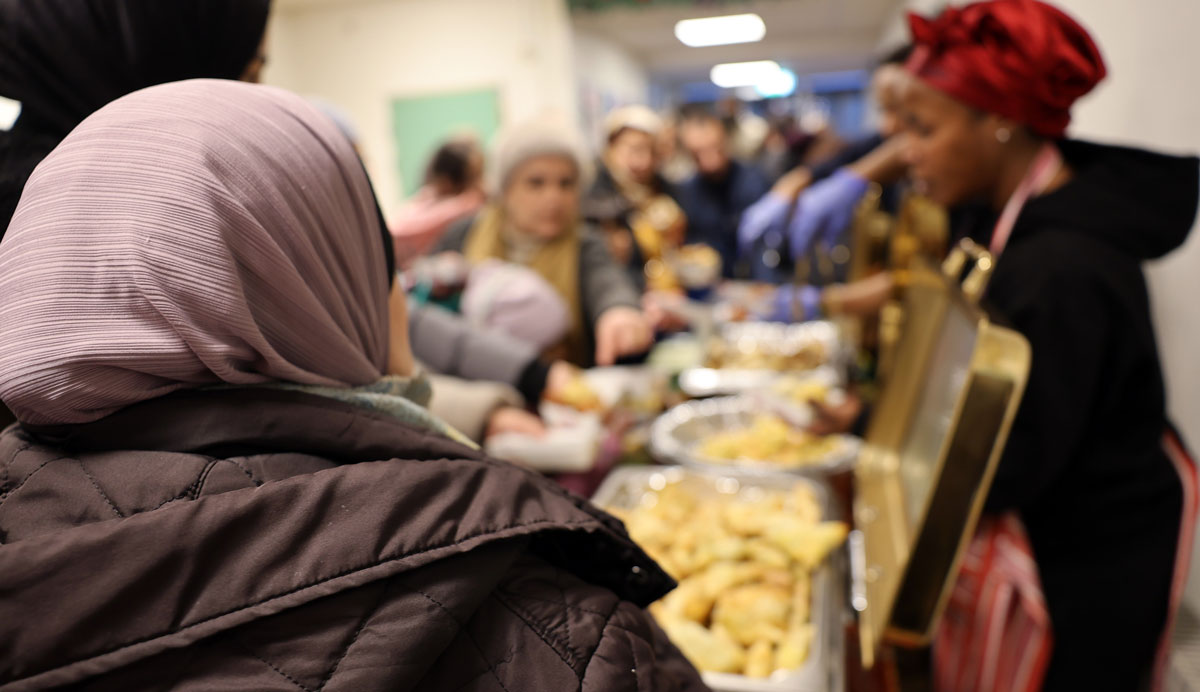 Kvinna serverar samosas och annan mat från buffé.