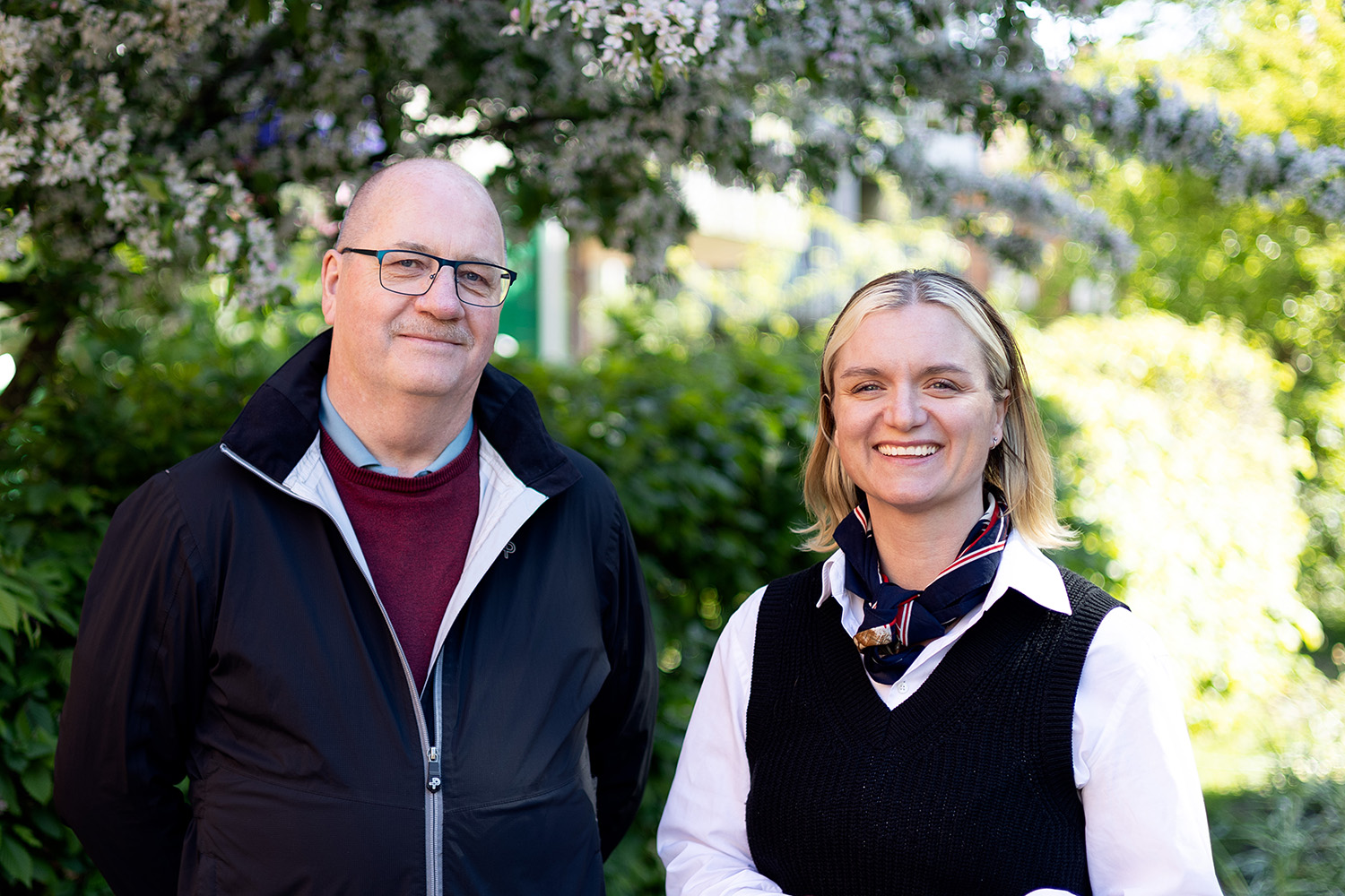 En man och en kvinna som ler tittar in i kameran. 