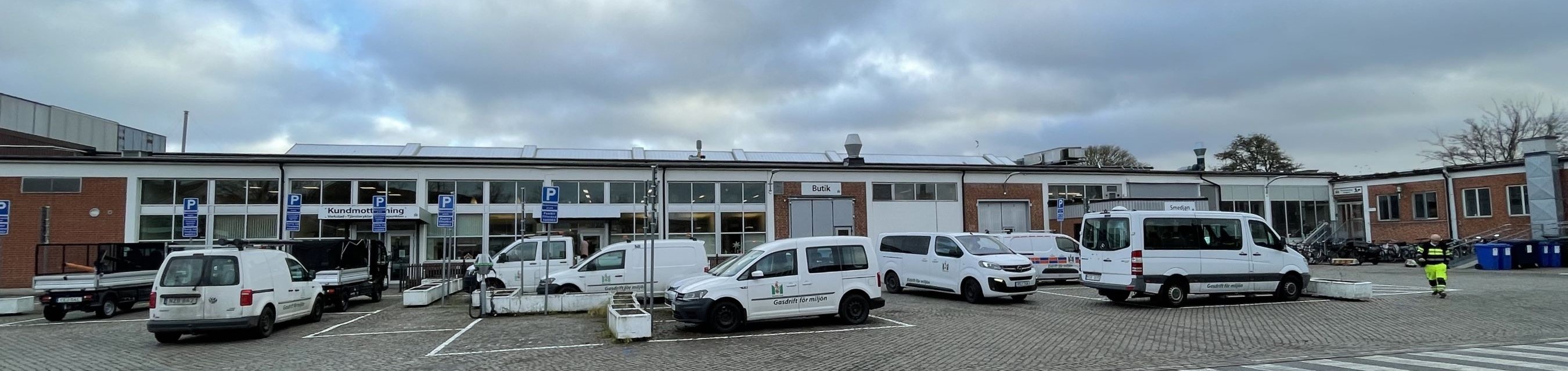 Låg kontors- och verkstadsbyggnad i tegel. Framför står Malmö stads vita tjänstefordon.