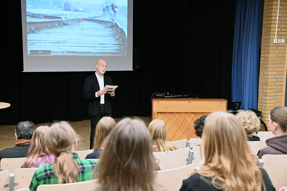 Jan Hase, står framför en skolklass och berättar.
