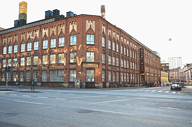 Äldre industriell vacker tegelbyggnad på stadsgata.