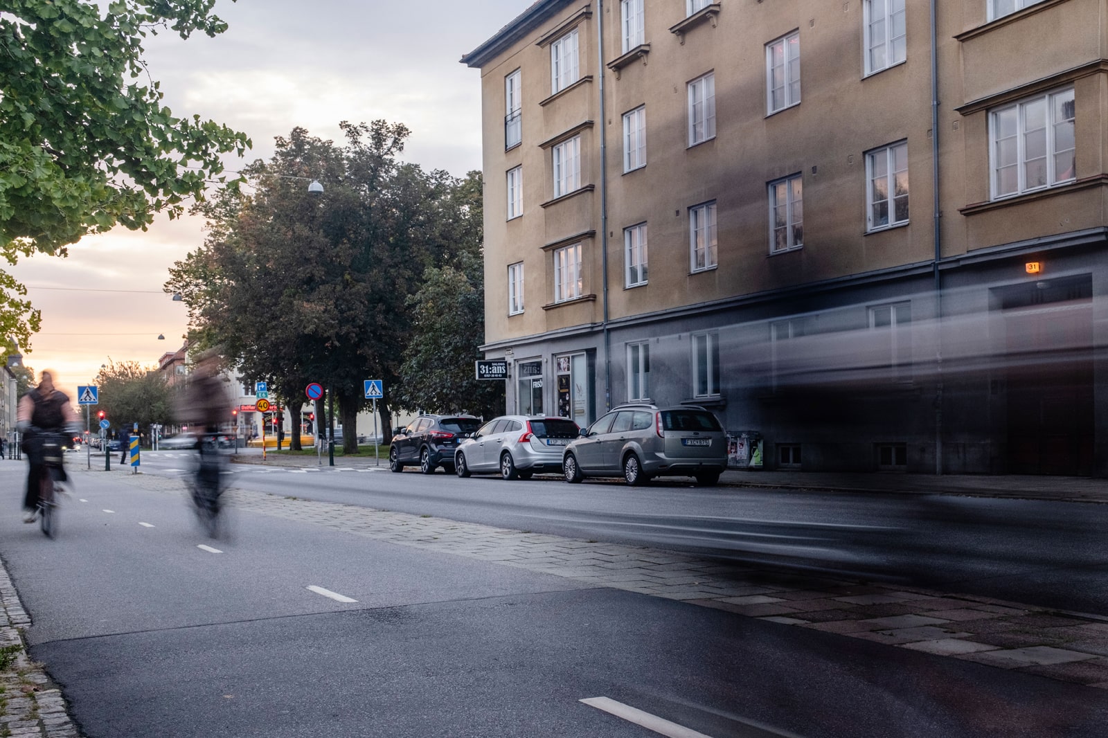 Cykelbana i Malmö med cyklister som svishar förbi med träd i bakgrunden.