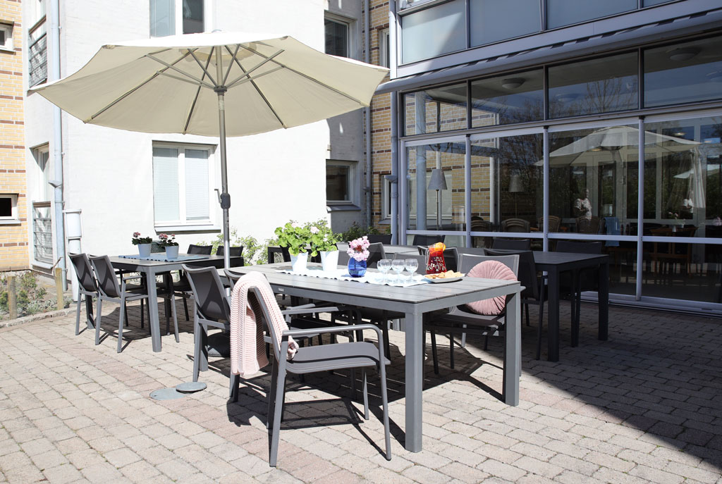 Vi kan fika och äta ute i solen, med ett parasoll som skydd.