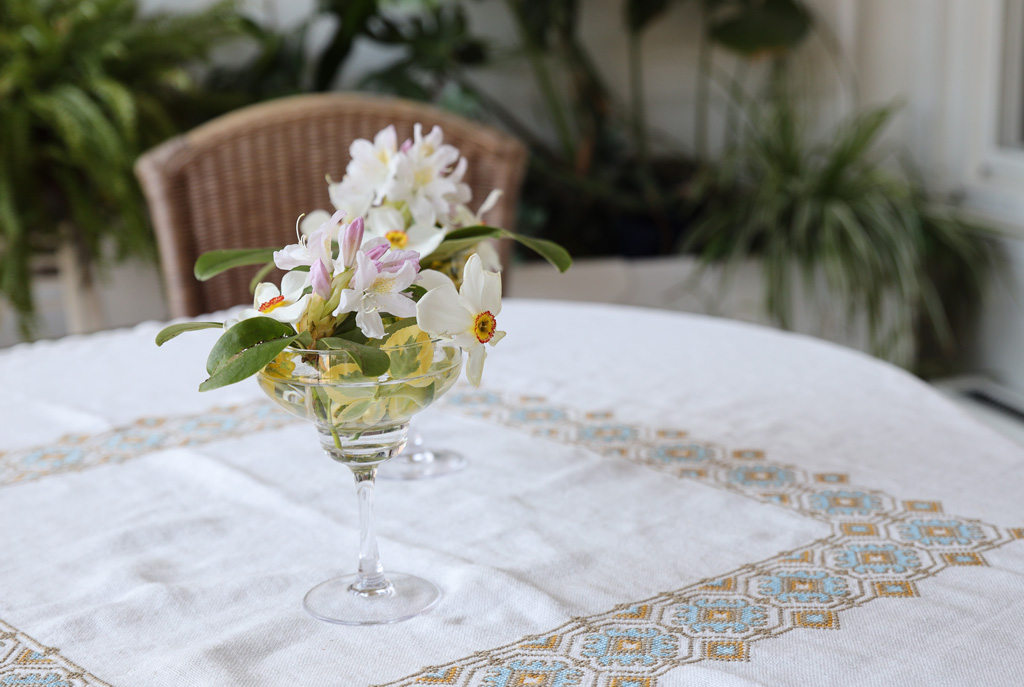Ett litet glas med små blommor och en fin duk gör genast rummet mer trevligt.