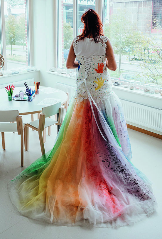 Brudklänningen har barnen dekorerat med handavtryck och regnbågens alla färger