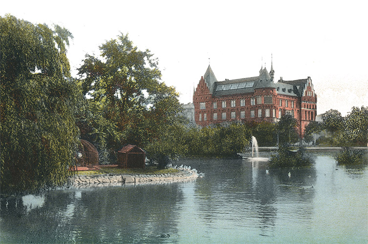 Vykort som föreställer slottet på Malmö stadsbibliotek, med vatten och grönska i förgrunden.