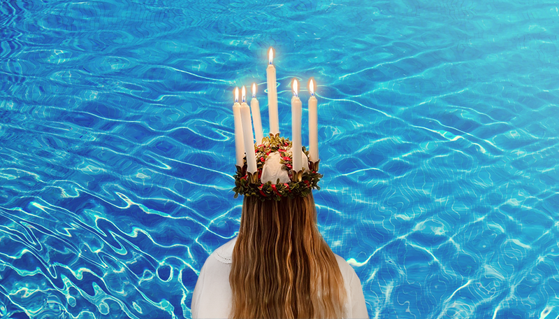Lucia med tända ljus i kronan framför poolbakgrund.
