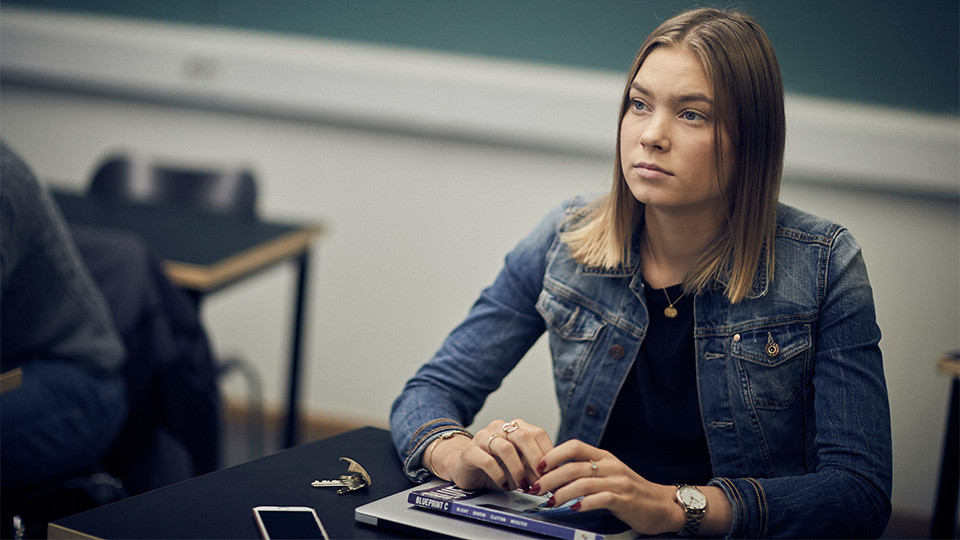 En allvarlig elev sitter vid sin bänk.
