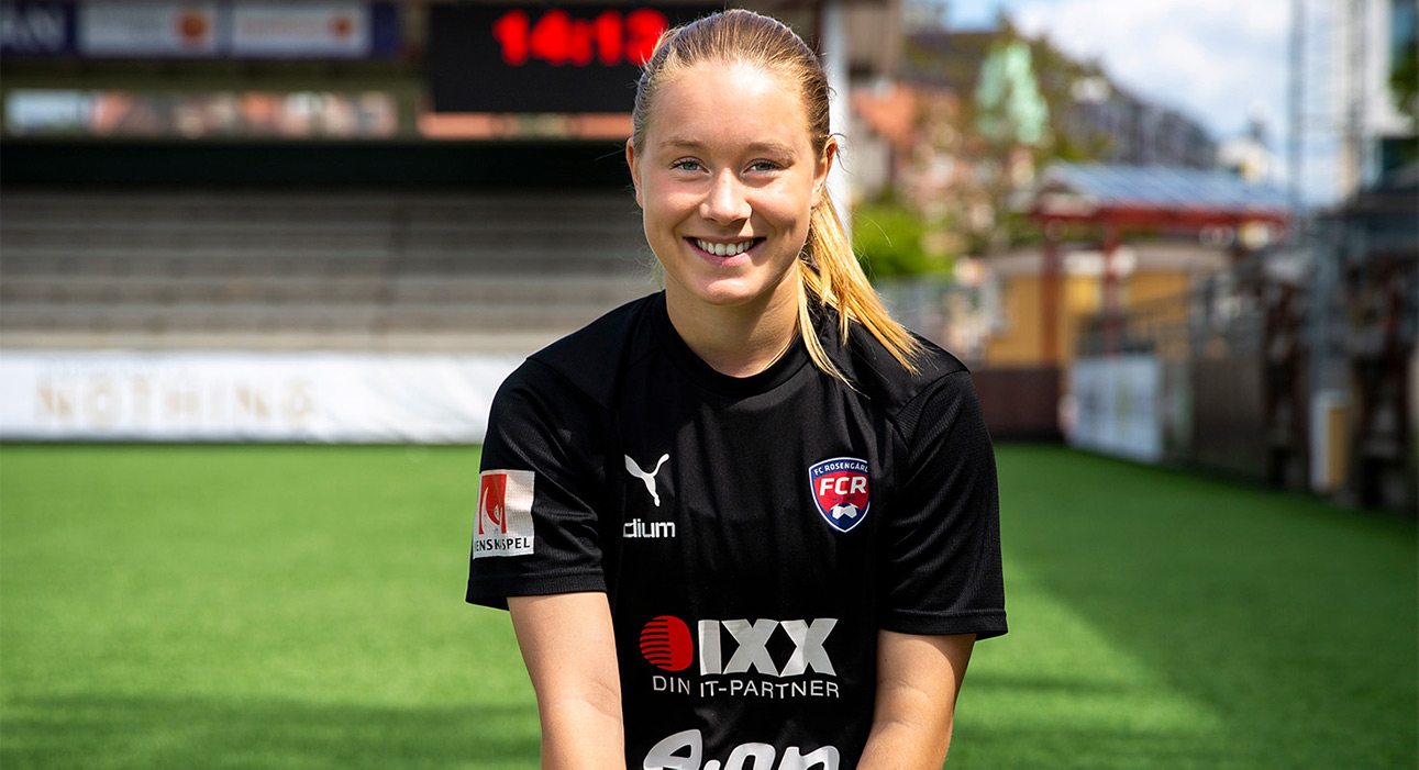 En fotbollstjej ler in mot kameran.