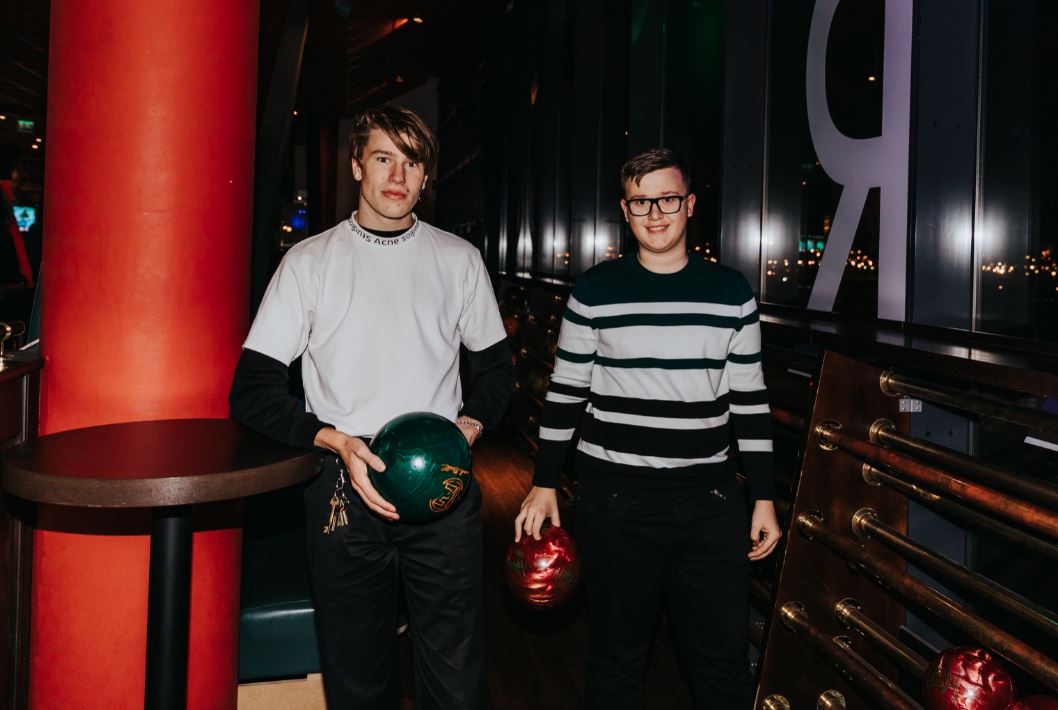 Två killar som tittar in i kameran med varsitt bowlingklot i handen
