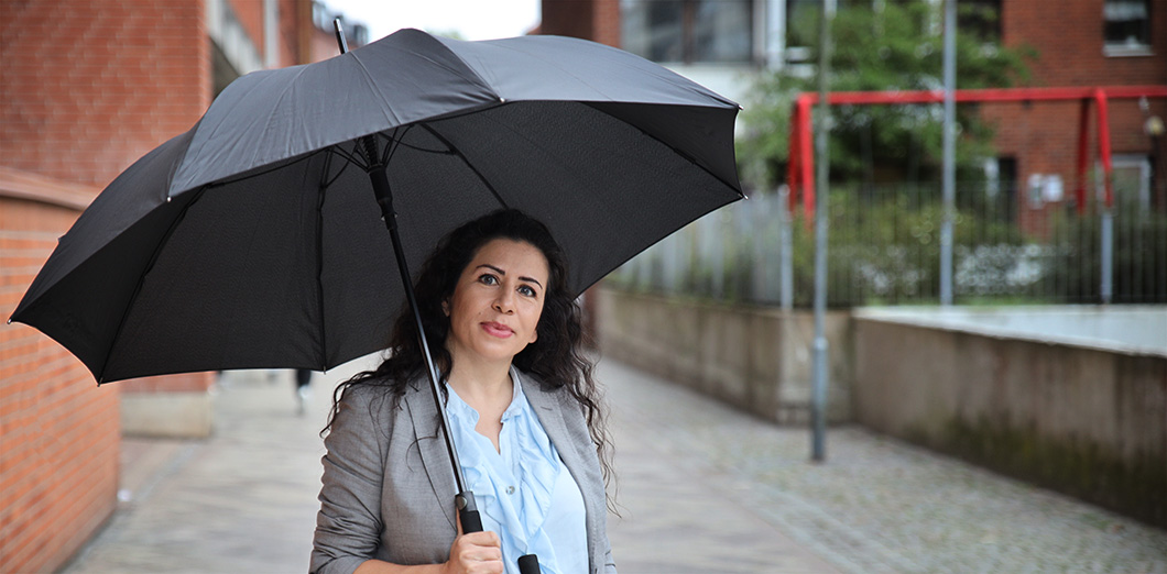 Leila Hashtroudi tar skydd under ett paraply.
