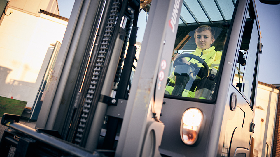 En elev i varselkläder kör en truck.