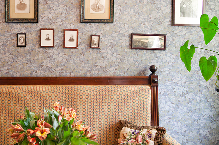 På väggarna hänger porträtt och andra äldre fotografier.