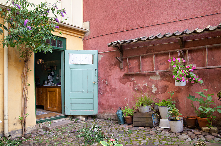 På baksidan av huset ligger en kullerstensbelagd innegård.