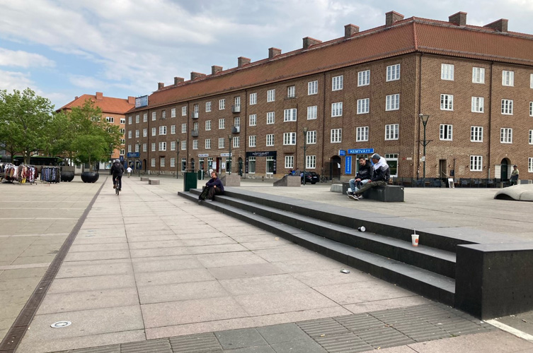 Öppet torg med flerfamiljshus i bakgrunden.