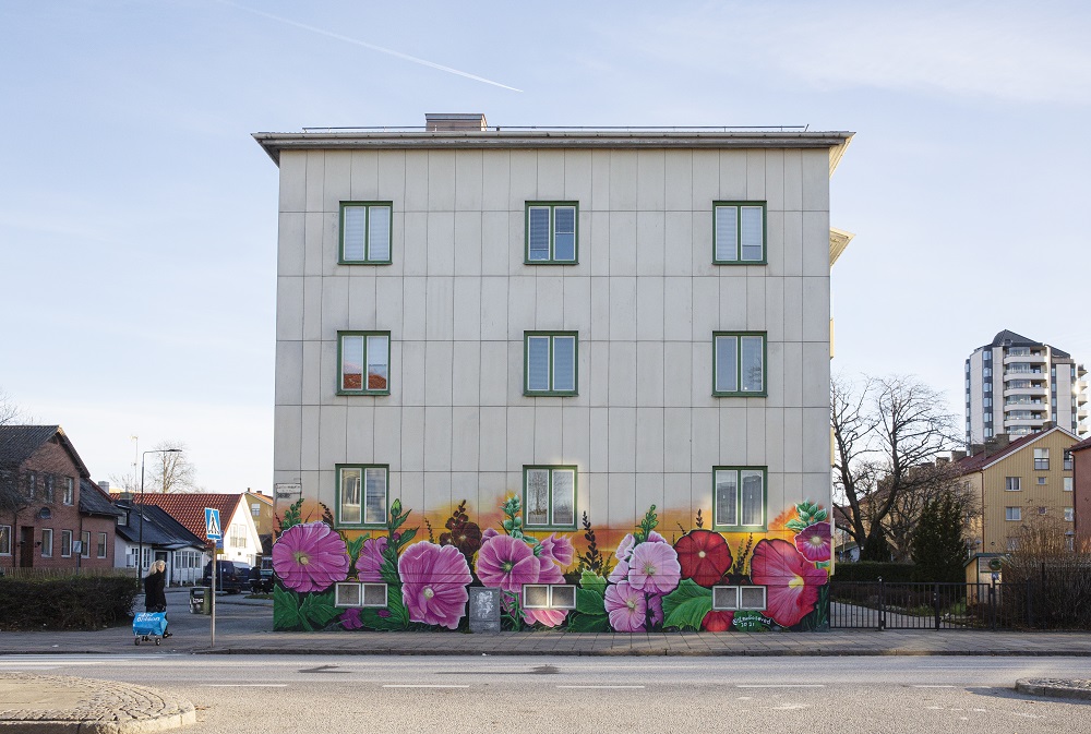 Muralmålning av blommor på byggnad.