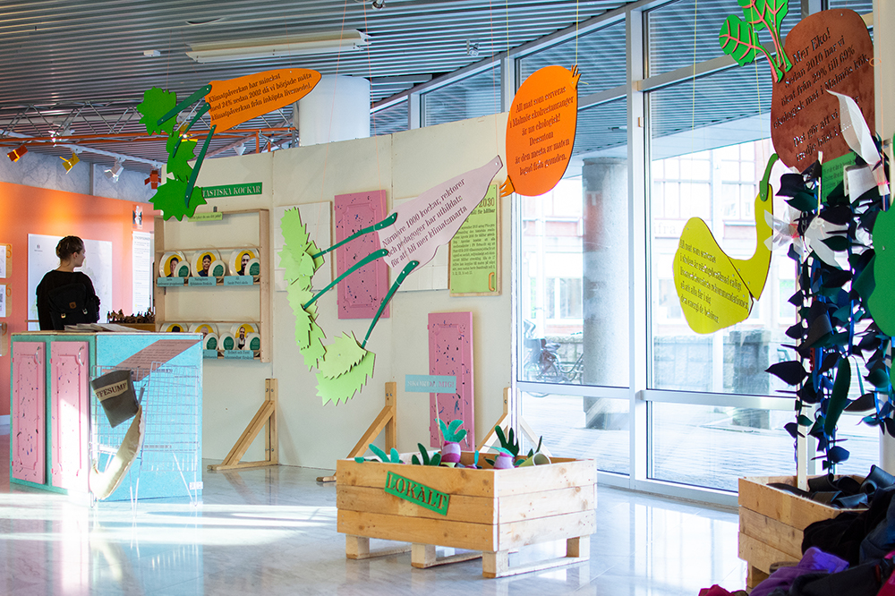 Utställning i stadshuset. Grönsaksskyltar med text om stadens arbete med klimatsmart mat.