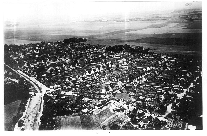 Flygfoto över bostadsområde och grönytor.