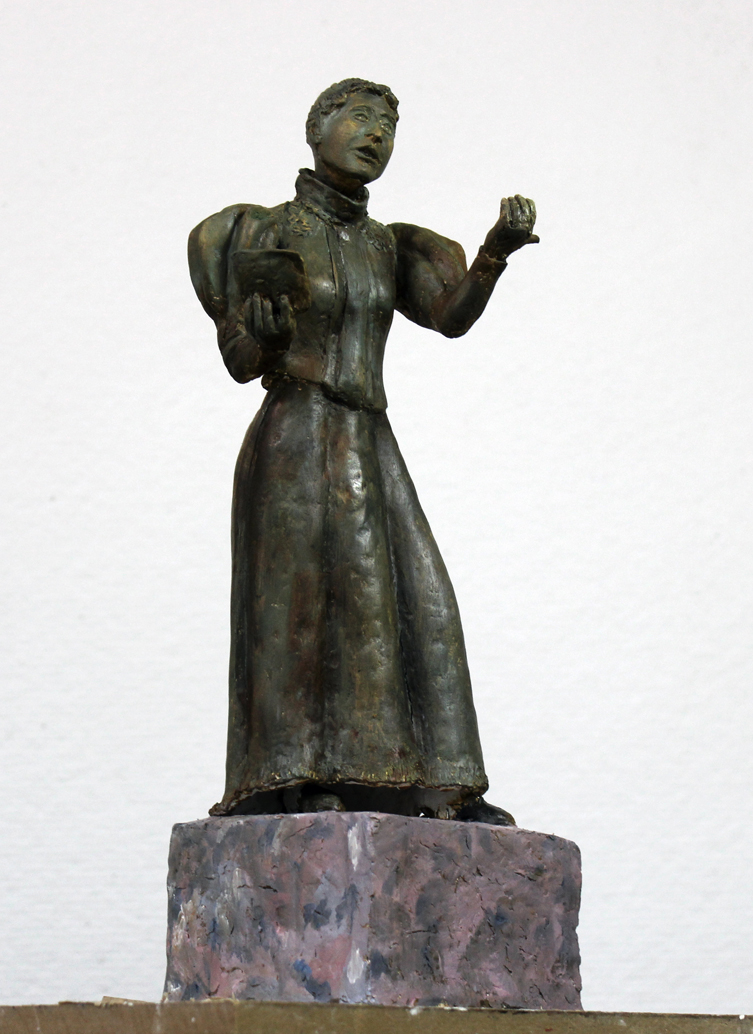 Modell av skulpturen. Bronsskulptur i formen av en kvinna med klänning som läser ur en bok.