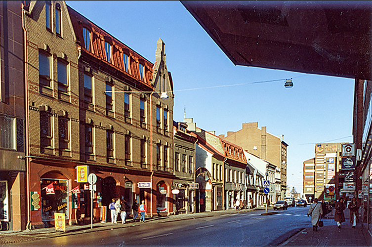 Nyare bild på Djäknegatshusen med asfalterad gata framför.