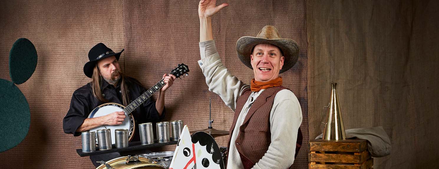 En person på käpphäst och en som spelar banjo.