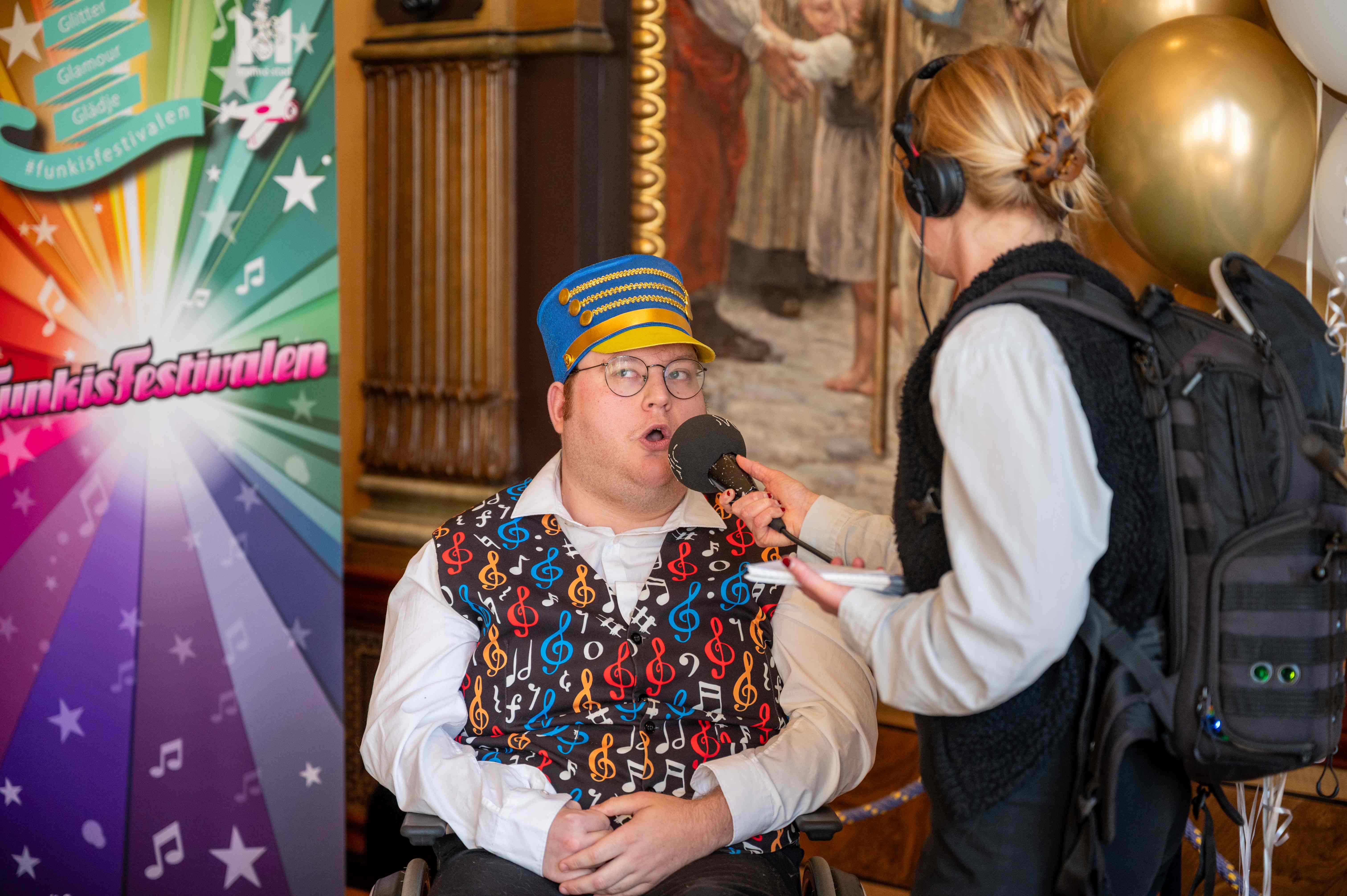 William pratar i en mikrofon som en journalist håller i och intervjuar honom med.