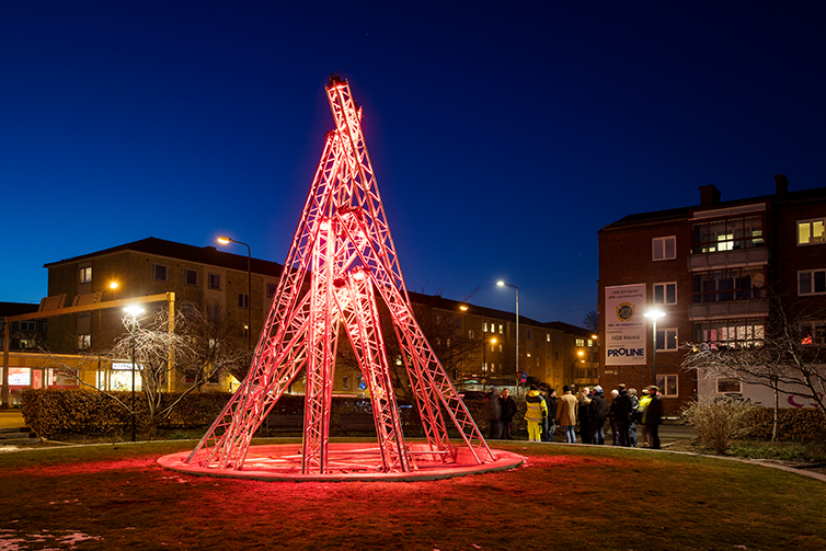 Flera metalstålar som lyser rött som är uppställda mot varandra för att bilda en ljusinstallationer.