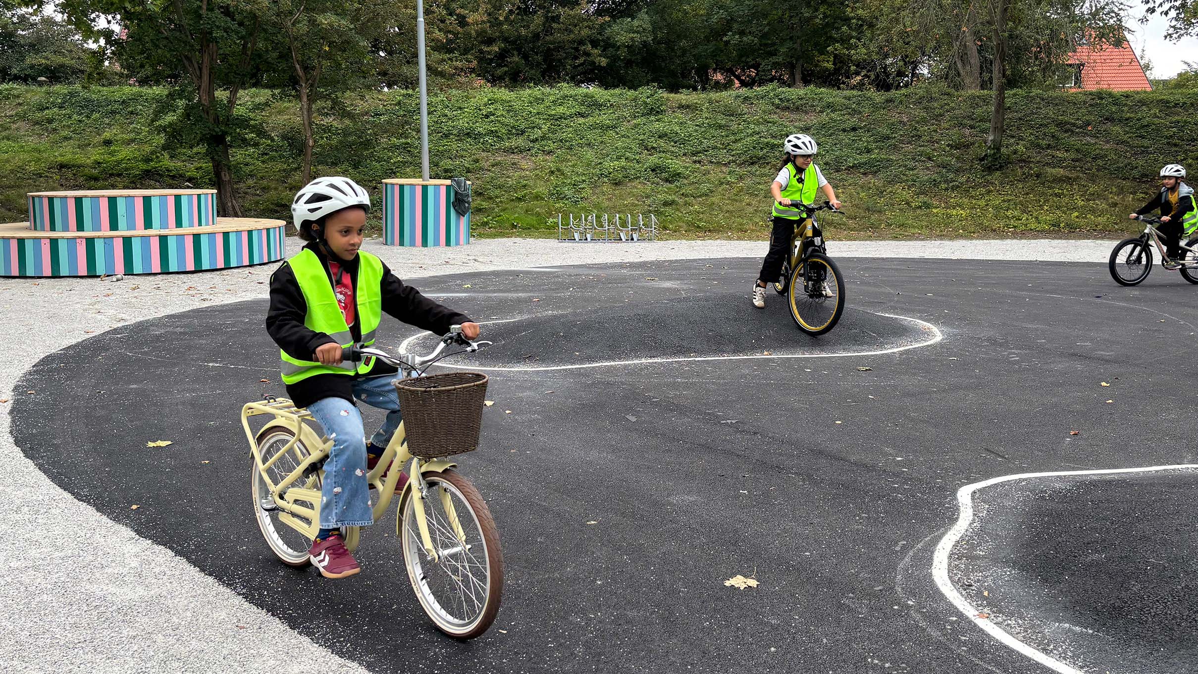 Barn cyklar över och bredvid gupp på asfalt.