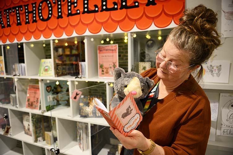 Bibliotekarie läser för en av gästerna på katthotellet.