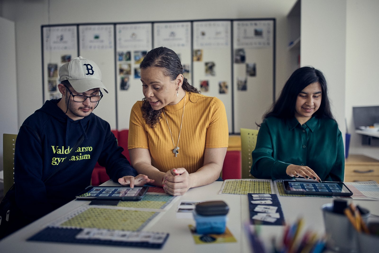 Två elever sitter med sin lärare.