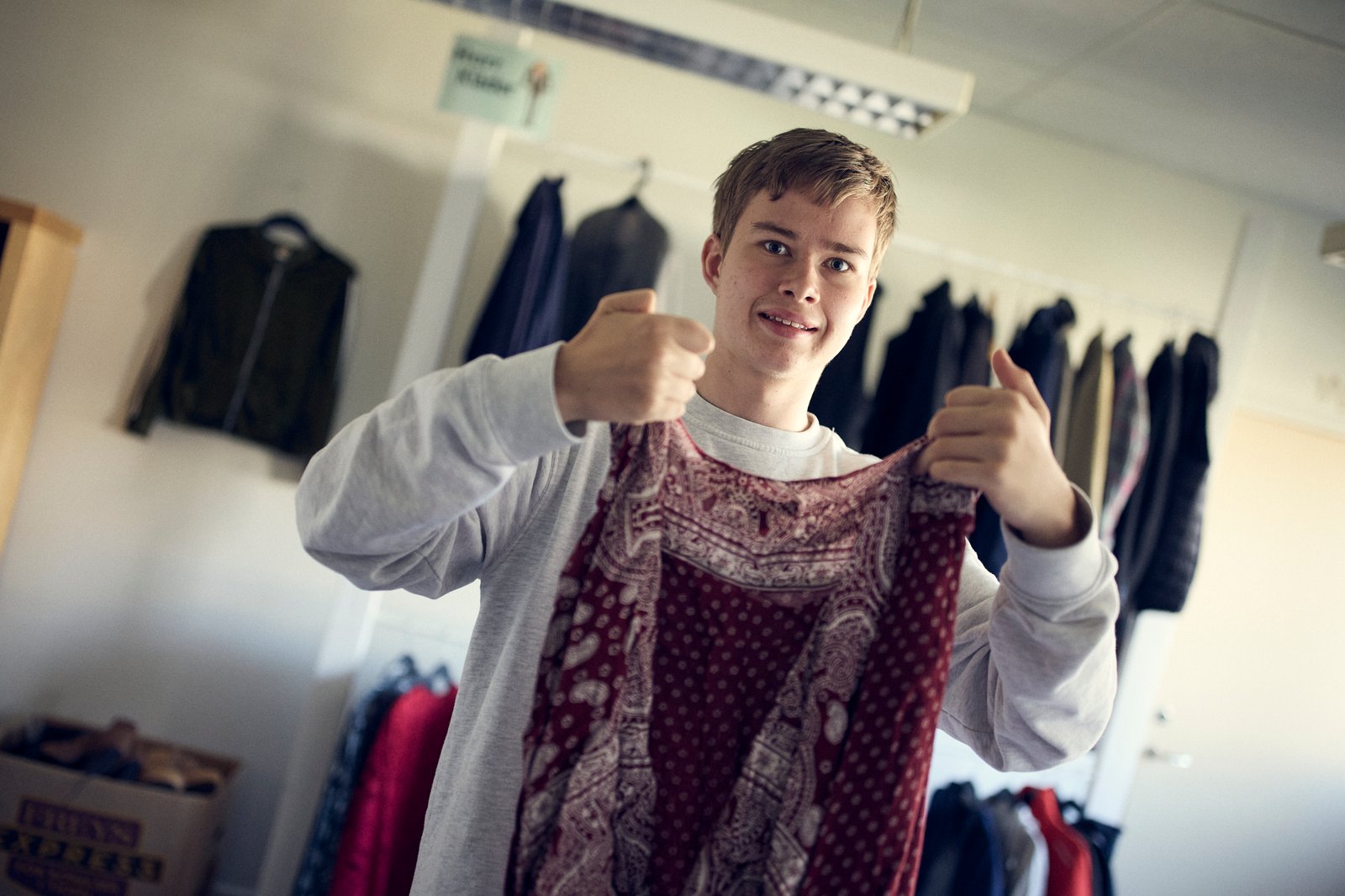 En elev håller i en tröja som han ska vika. 