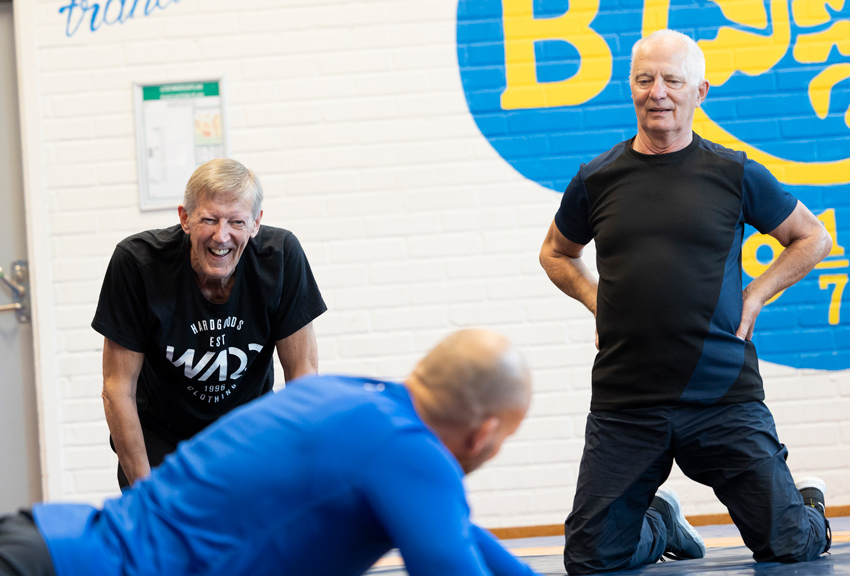 Tre män brottas med varandra i Limhamns brottarklubbs lokaler.