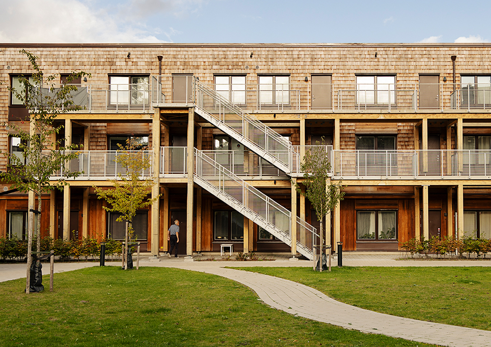 Ett hus byggt i trä med trappor och loftgångar på utsidan