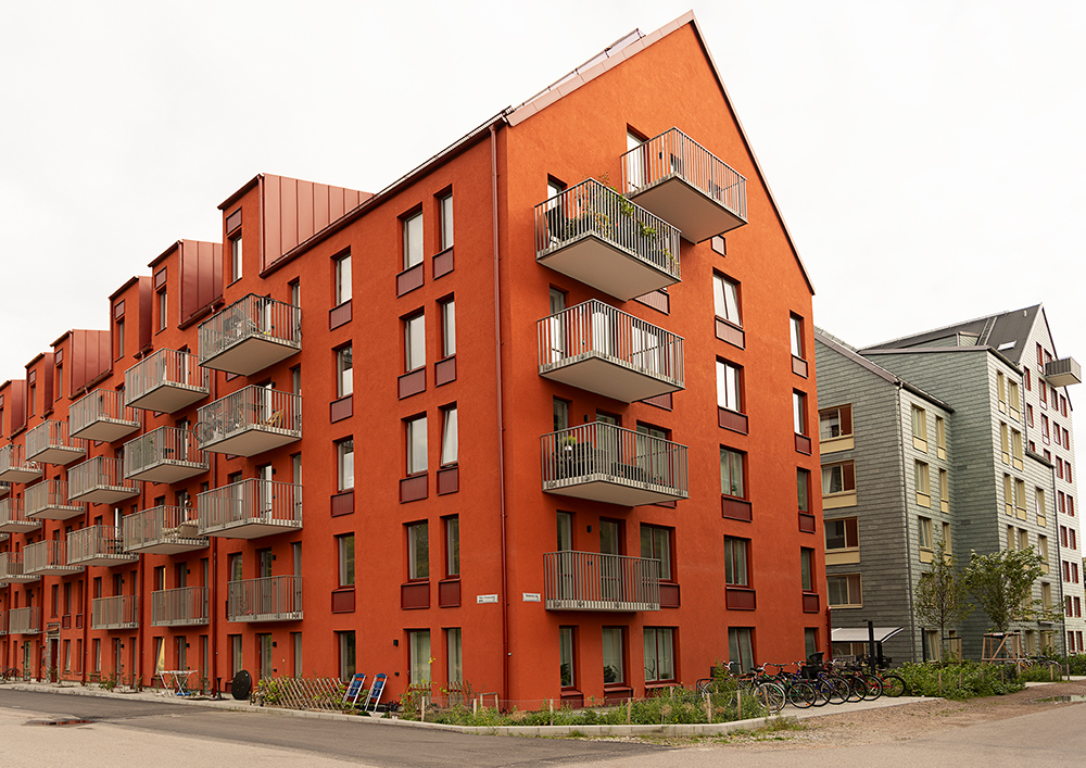 Ett klarrött hus med grå balkonger