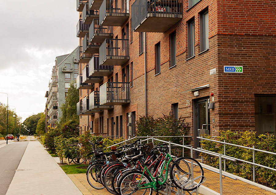 Ett hus byggt i tegel och cykelparkering i förgrunden