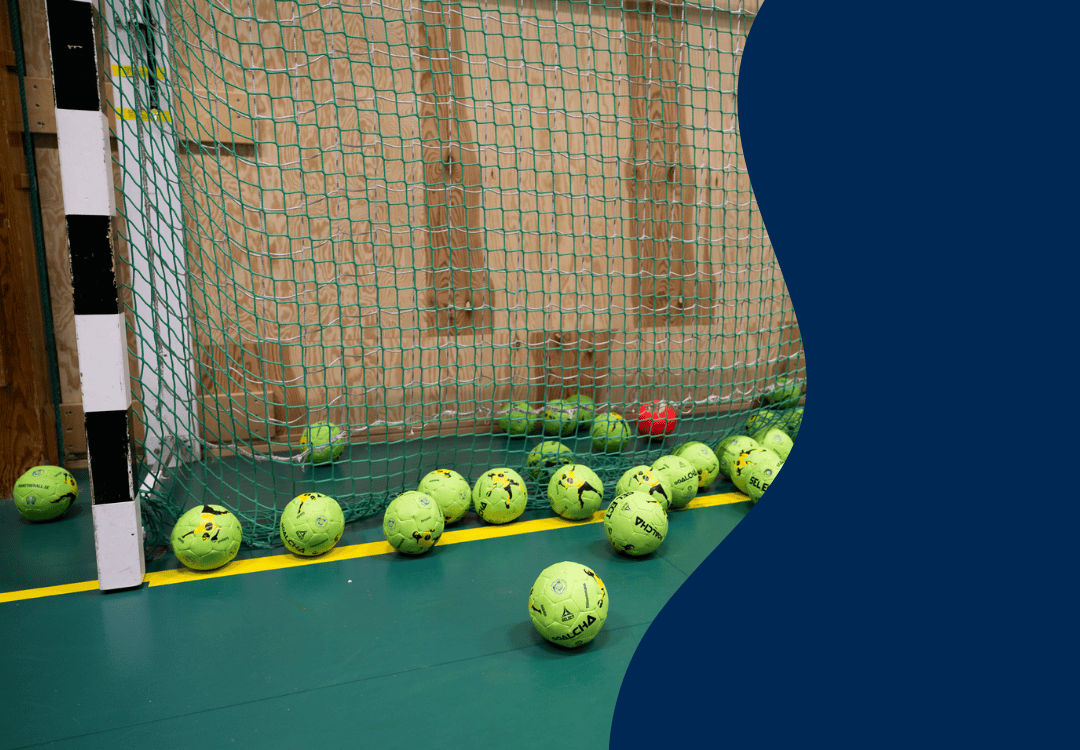 Foto på flera handbollsbollar som ligger i ett mål.