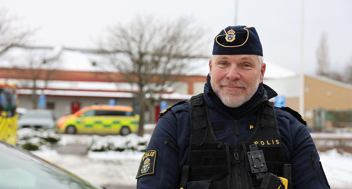 Magnus Björn-Bentzen står lutad mot en polisbil utanför ett snöigt Rosengårds ip.